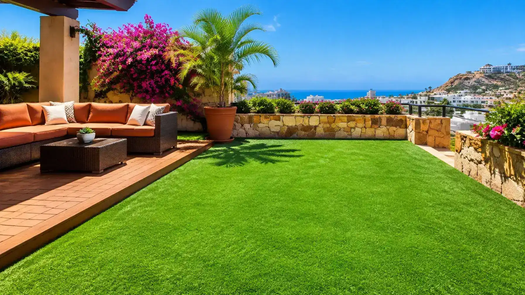 Pasto sintético en terraza con deck de madera y camastros