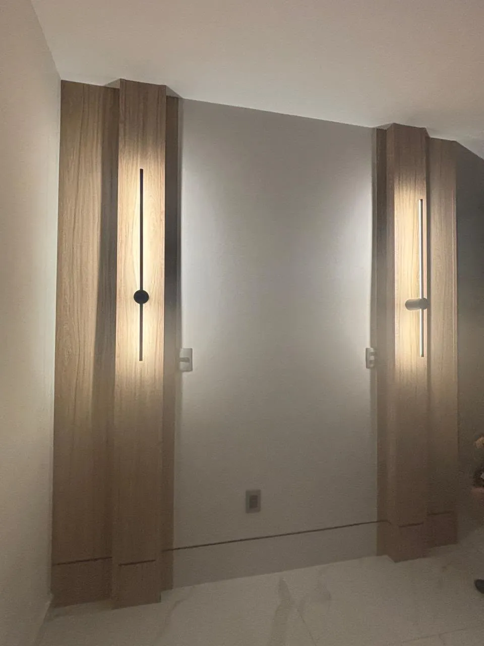 Lambrín vertical de madera y apliques lineales en la cabecera de una recámara en Morelia