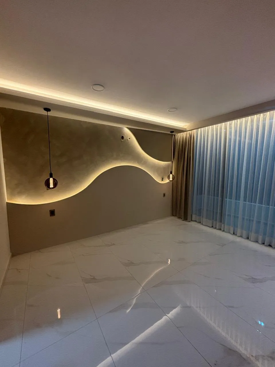 Recámara en Morelia con muro texturizado curvo, luz LED, cortinas sheer y cortina pesada de piso a techo